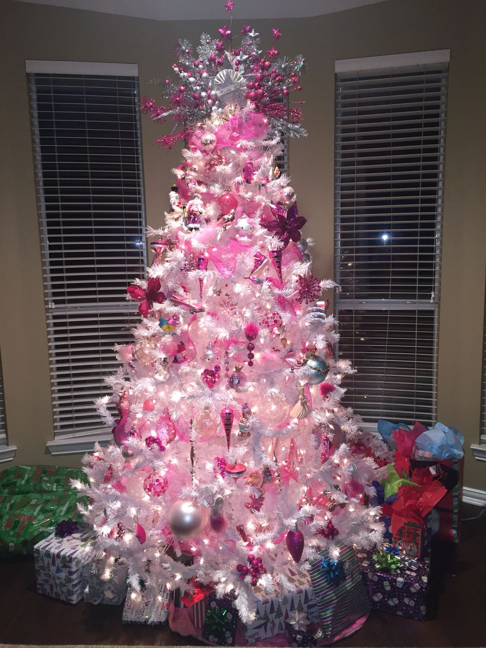 A Pink And White Christmas Tree With Ornaments